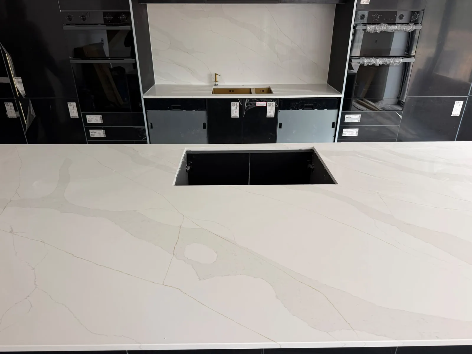 Marvra worktop installation: white with gold veining, black units, undermount sink