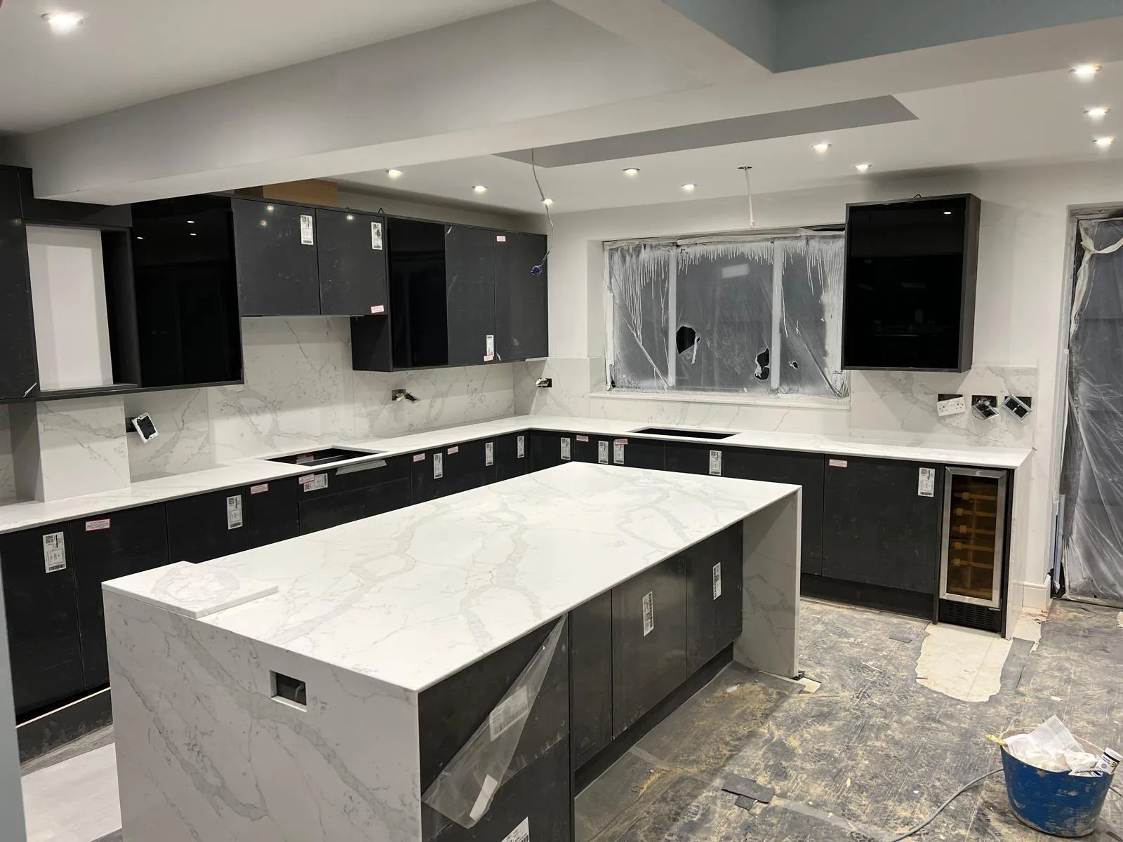 Marvra worktop installation: white with grey veining, island in a black gloss kitchen